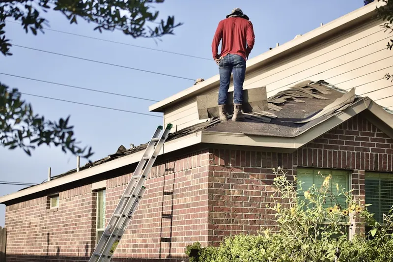 Professional roofer working on a residential roof in Dixie Park